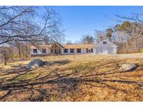 Ranch home with attached garage, stone accents, and a spacious yard at 1609 N County Line Rd, Lithia Springs, GA 30122