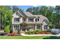 Charming two-story home boasts a manicured lawn, beautiful landscaping, and a welcoming front porch at 5330 Lake Redwine Nw Cv, Acworth, GA 30101