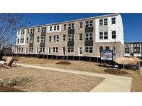 New construction townhome with brick facade, white trim, and a community green space at 2652 Brookview Nw Ln, Atlanta, GA 30318