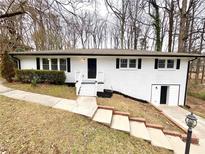 White brick ranch house with landscaping, steps, and a driveway at 1394 Yates Ave, Austell, GA 30106