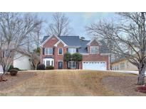 Brick two-story house with a large yard and attached garage at 6764 Blantyre Blvd, Stone Mountain, GA 30087