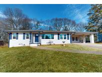 Ranch style home with white brick exterior, blue shutters, and a well-maintained lawn at 464 Maxwell Rd, Roswell, GA 30075