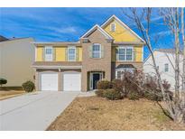 Brick and vinyl two-story home with a three-car garage and landscaping at 7336 Toccoa Cir, Union City, GA 30291