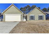 Ranch style home with attached garage and a well-maintained lawn at 175 Paris Dr, Lawrenceville, GA 30043