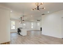 Bright living room featuring wood floors, recessed lighting, and an open layout flowing into the kitchen at 1910 Connally Dr, East Point, GA 30344