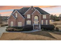 Brick two-story house with landscaping and a large driveway at 4265 Eddie Byrd Ln, Loganville, GA 30052