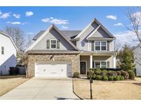 Two-story house with gray siding, brick accents, and a two-car garage at 6760 Grove Meadows Ln, Cumming, GA 30028