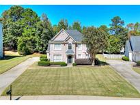 Brick house with a manicured lawn and driveway at 1130 Maple Creek Rdg, Loganville, GA 30052
