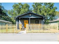 Charming gray house with yellow door, wood fence, and covered porch at 1043 Smith Sw St, Atlanta, GA 30310
