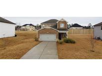 Two-story brick home with attached garage and driveway at 337 Amsterdam Way, Hampton, GA 30228