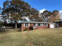 Brick ranch house with a spacious yard and mature trees at 1261 Cliffwood Se Dr, Smyrna, GA 30080