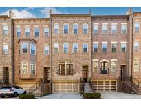 Brick townhome with 3-story elevation, attached garage, and steps leading to the entrance at 1939 Ridgemont Ln, Decatur, GA 30033