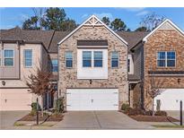 Brick front townhouse with a two-car garage and landscaping at 3360 Shelley Dr, Cumming, GA 30041