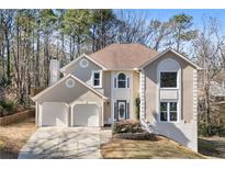 Two-story house with beige exterior, two-car garage, and landscaping at 1362 Meadow Creek Nw Way, Acworth, GA 30102