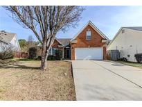 Brick house with attached garage and landscaping at 1708 Queen Victoria Ct, Locust Grove, GA 30248