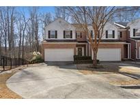 Brick front townhouse with 2-car garage, and manicured landscaping at 2128 Mill Garden Run, Buford, GA 30519