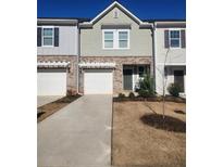 Two-story townhome with attached garage and landscaped front yard at 137 Swindon Dr, Mcdonough, GA 30253