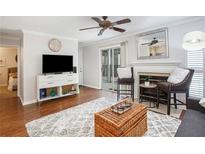 Bright living room with fireplace, hardwood floors, and sliding glass door to patio at 631 Granville Ct, Atlanta, GA 30328