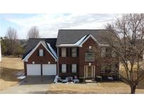 Brick two-story house with a two-car garage and mature trees at 12558 Lakeside Pkwy, Fayetteville, GA 30215