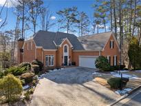 Brick home with a paved driveway and landscaping at 2585 Club Springs Dr, Roswell, GA 30076