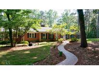 Brick ranch house with landscaped yard and winding brick pathway at 200 Mcguirts Bridge Rd, Covington, GA 30014