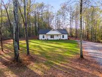 Charming one-story home features a well-manicured lawn and a tranquil wooded surrounding at 410 N Carroll N St, Bowdon, GA 30108