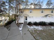 Inviting yellow house exterior with a white fence and walkway at 1612 Alexandria Se Ct, Marietta, GA 30067