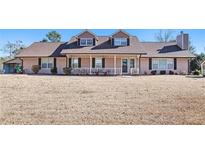Two-story house with brown roof, porch, and landscaping at 5024 Klondike Rd, Lithonia, GA 30038