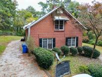Brick house with mature landscaping and a large yard at 1345 Gun Club Nw Rd, Atlanta, GA 30318