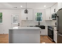 Modern kitchen with stainless steel appliances, white cabinets, and center island with countertop at 904 Fairburn - (In A Subdivision) Nw Rd, Atlanta, GA 30331