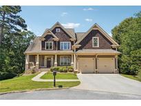 Two-story house with a brown shingle exterior, beige accents, and a three-car garage at 15 Amberly Ln, Cartersville, GA 30121
