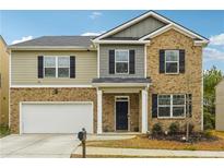 Two-story brick home with a large front yard and attached garage at 3811 River Rock Rd, Lithonia, GA 30038