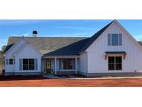White farmhouse exterior with gray roof and blue shutters at 137 Woodfin Way, Social Circle, GA 30025