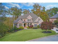 Brick two-story house with landscaped lawn and driveway at 141 Grandmar Chase, Canton, GA 30115