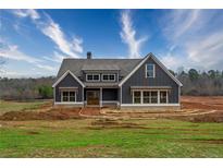 New home featuring board and batten siding, well-placed windows and professional, modern color palette at 181 Woodfin Way, Social Circle, GA 30025
