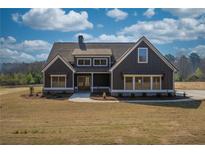 Charming home featuring a gray exterior, covered front porch, beautiful windows, and landscaped front yard at 181 Woodfin Way, Social Circle, GA 30025