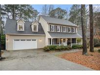 Charming two-story traditional home boasts a 2-car garage and inviting front porch with black shutters at 515 Lees Sw Trce, Marietta, GA 30064