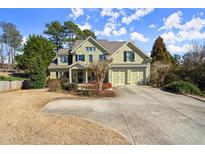 Charming two-story home with a well-manicured front yard and a spacious driveway leading to a two-car garage at 5025 Hidden Ct, Cumming, GA 30040
