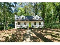 Charming white house with green door, surrounded by lush trees at 5144 Highland Trl, Acworth, GA 30102