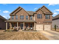 Two-story brick house with a large front porch and two-car garage at 120 Julia Ann Ln, Covington, GA 30016