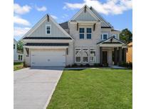 Beautiful two-story home with white brick, a two-car garage, and professionally landscaped front yard at 6745 Dahlgren Ct, Cumming, GA 30028