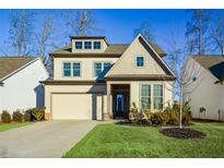 Two-story house with beige siding, a large driveway and landscaping at 234 Fieldbrook Xing, Canton, GA 30115