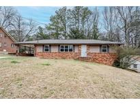 Charming single-story home with a brick facade and well-manicured lawn at 2937 Cascade Sw Rd, Atlanta, GA 30311