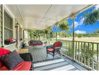 Inviting covered porch with wood floors, hanging swing, and seating with views of the surrounding landscape at 4656 Bryant Rd, Snellville, GA 30039