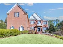 Charming two-story brick home with manicured lawn and traditional architectural details on a sunny day at 2025 Fife Ridge Ct, Roswell, GA 30075