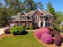 Stunning brick home featuring a manicured lawn, colorful azaleas, and classic architectural details at 701 Vinings Estates Se Dr, Smyrna, GA 30126