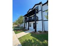 Charming two-story exterior showcases a balcony and well-manicured lawn, blending comfort with modern aesthetics at 391 Lincoln St, Woodstock, GA 30188