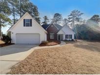 Brick and white two-story house with attached garage and landscaping at 835 Winding Grove Ln, Loganville, GA 30052