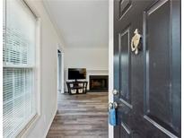 Bright entryway with wood-look floors leading to living room and fireplace at 1608 Vicksburg Pl, Atlanta, GA 30350