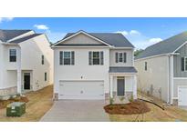Two-story house with white siding, gray accents, and a two-car garage at 12029 Conrad Circle, Hampton, GA 30228
